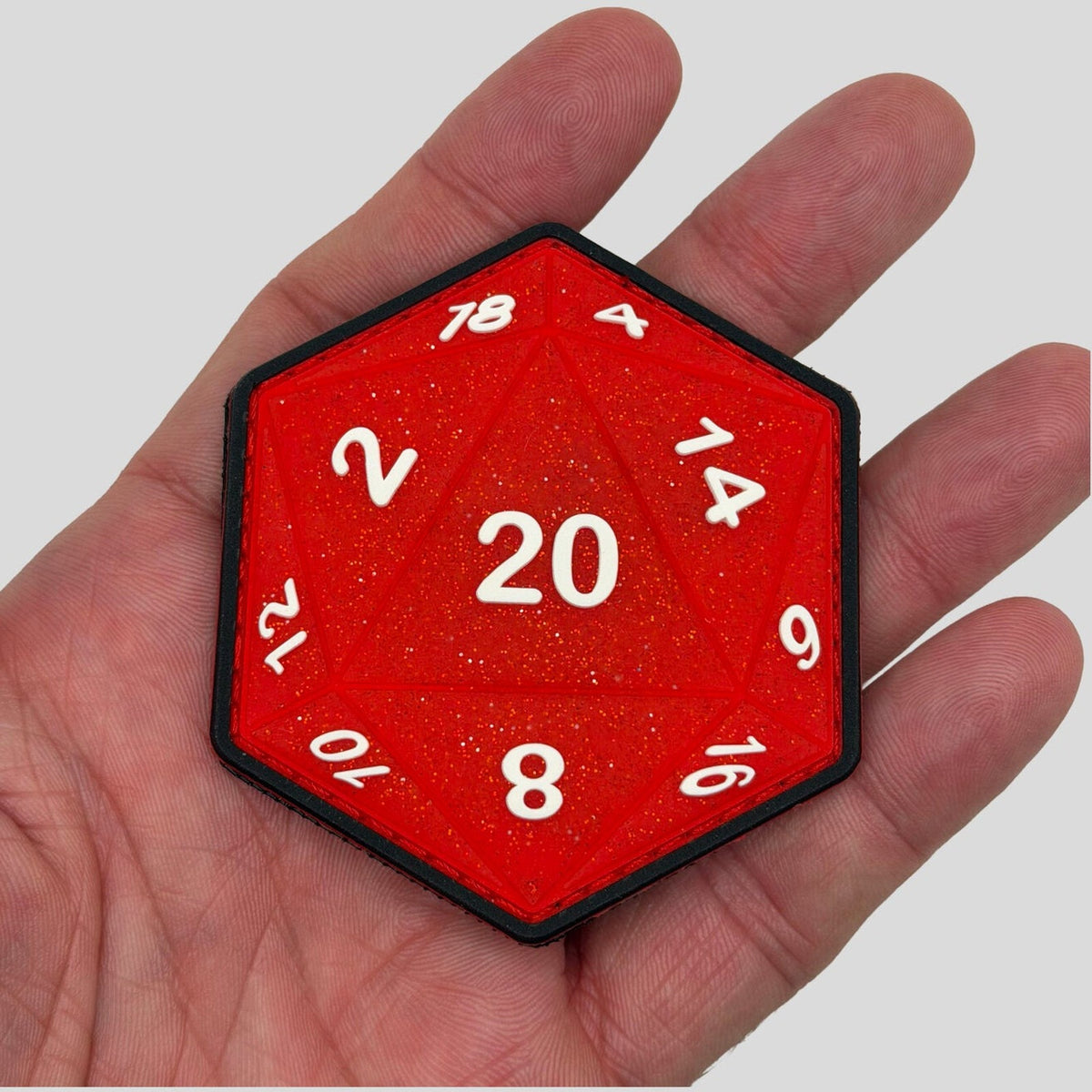 Sparkle SSR D20 Red 1st Edition PVC morale patch held in hand by Patch Fiend