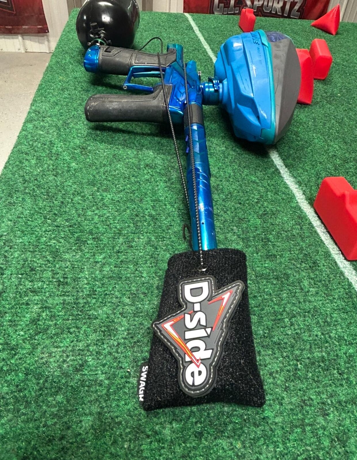 D-Side patch on a SWAGR Sleeve barrel cover, resting on a paintball strategy planning board with mini bunkers