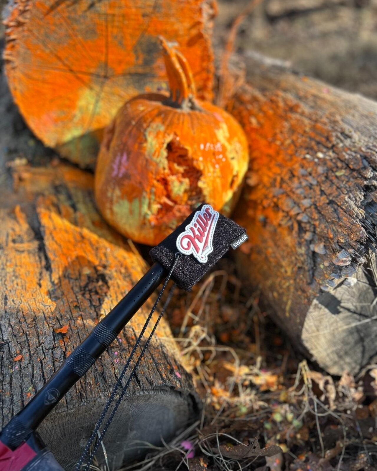 SWAGR Sleeve barrel cover with a Killer patch beside a paint-splattered pumpkin