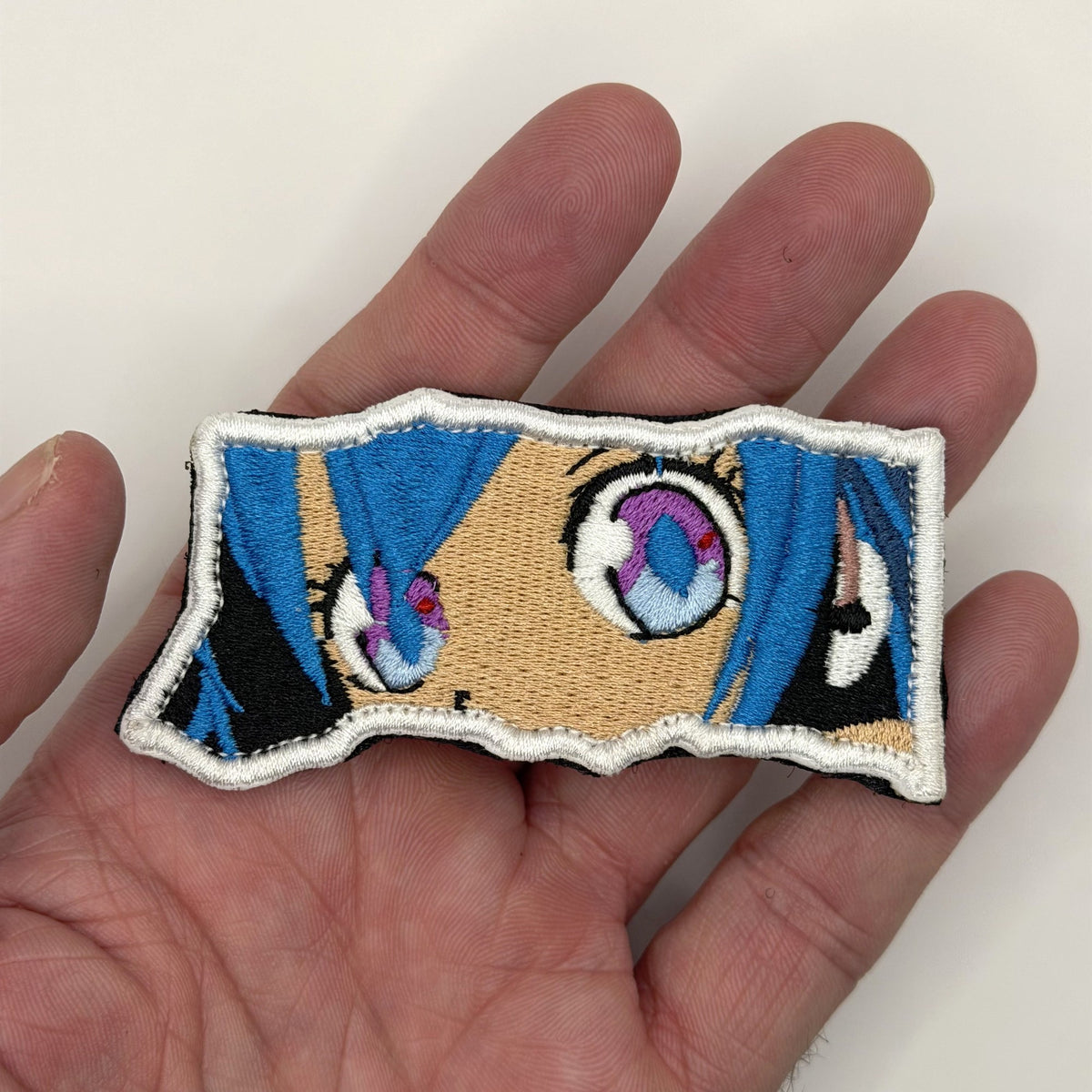 Virtual Diva Eyes embroidered patch held in hand for size, by FOTB Patches