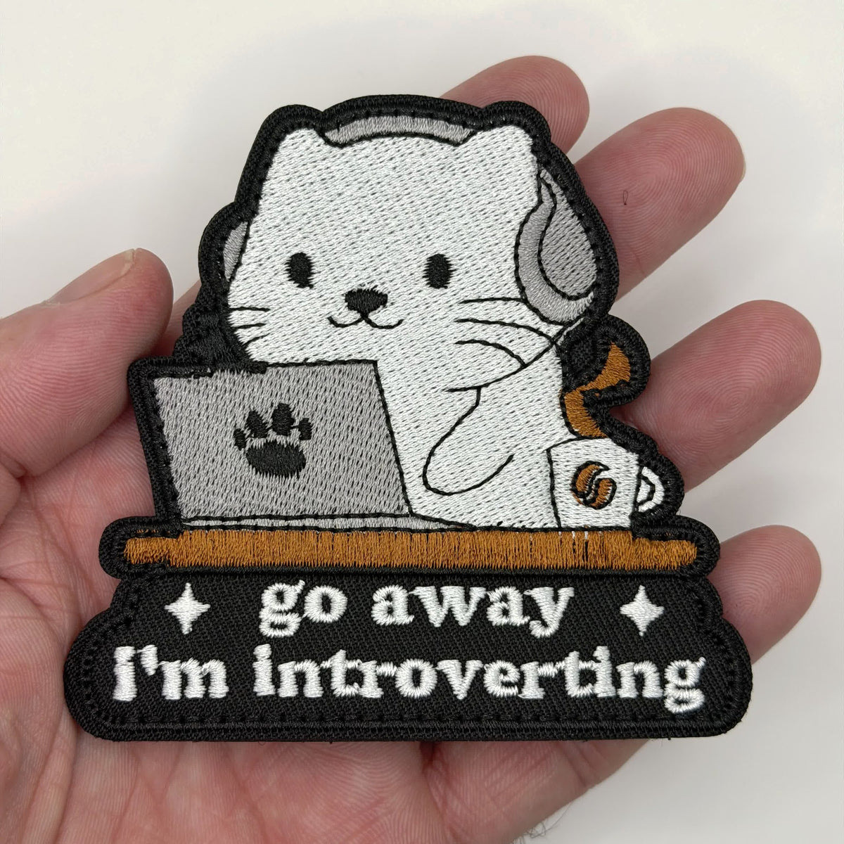 Go Away I'm Introverting cat embroidered patch held in hand for size, by FOTB Patches