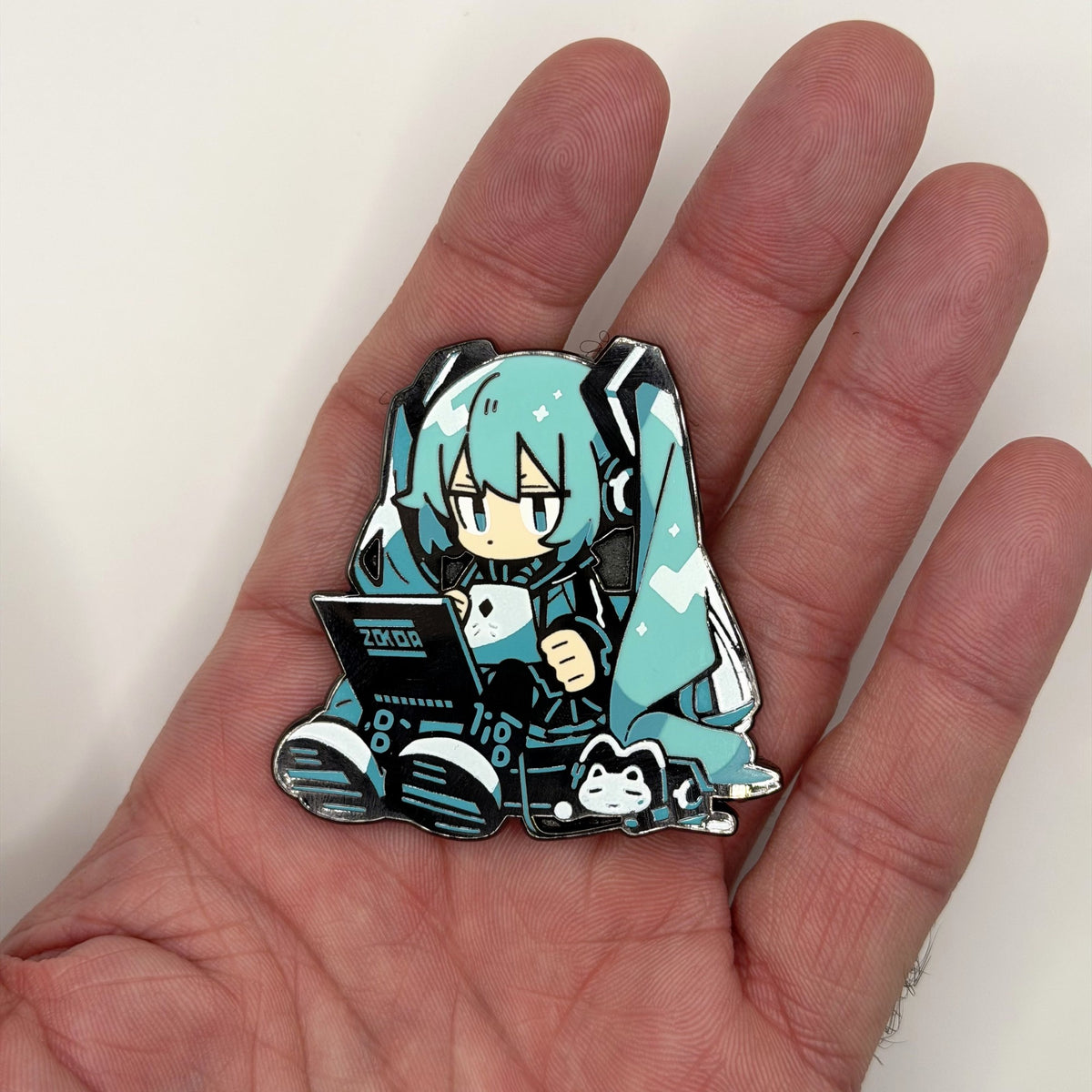 Virtual Diva laptop chibi metal patch held in hand for size, by FOTB Patches