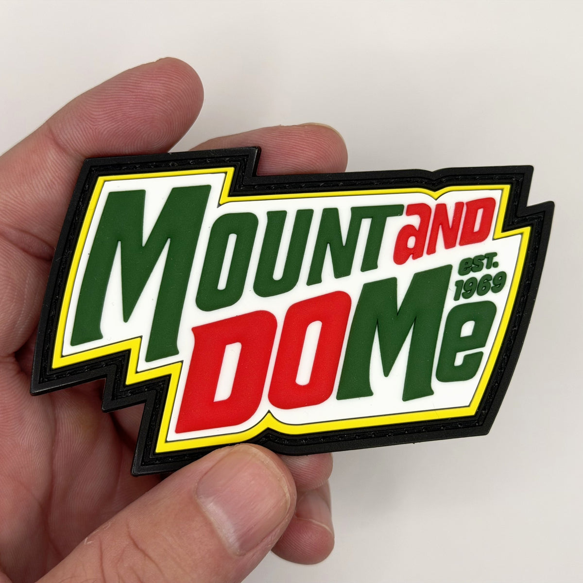 Mount and Do Me glow PVC patch held in hand, front