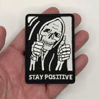 Stay Positive reaper embroidered patch held in hand for size, by FOTB Patches