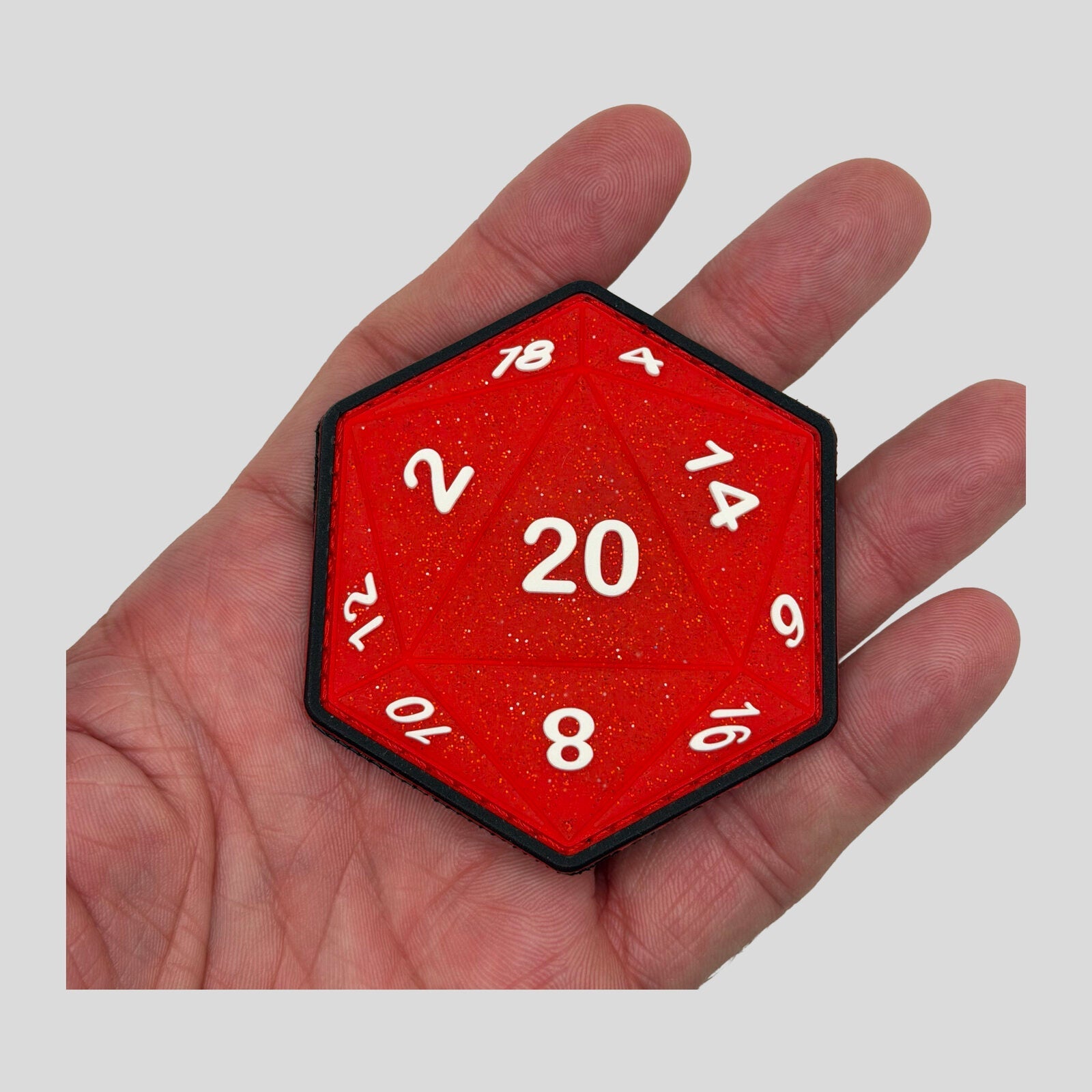 Sparkle SSR D20 Red 1st Edition PVC morale patch held in hand by Patch Fiend