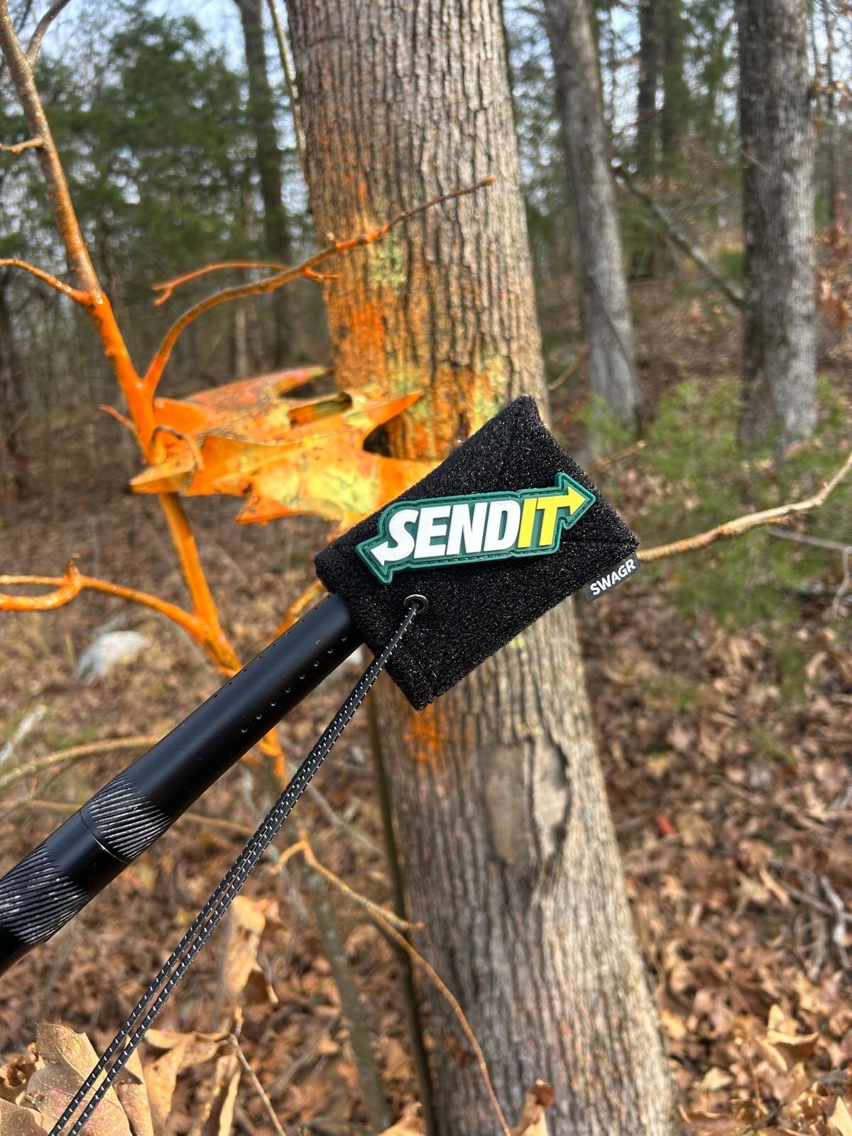 SWAGR Sleeve barrel cover with a Send It morale patch on a paintball marker in the woods